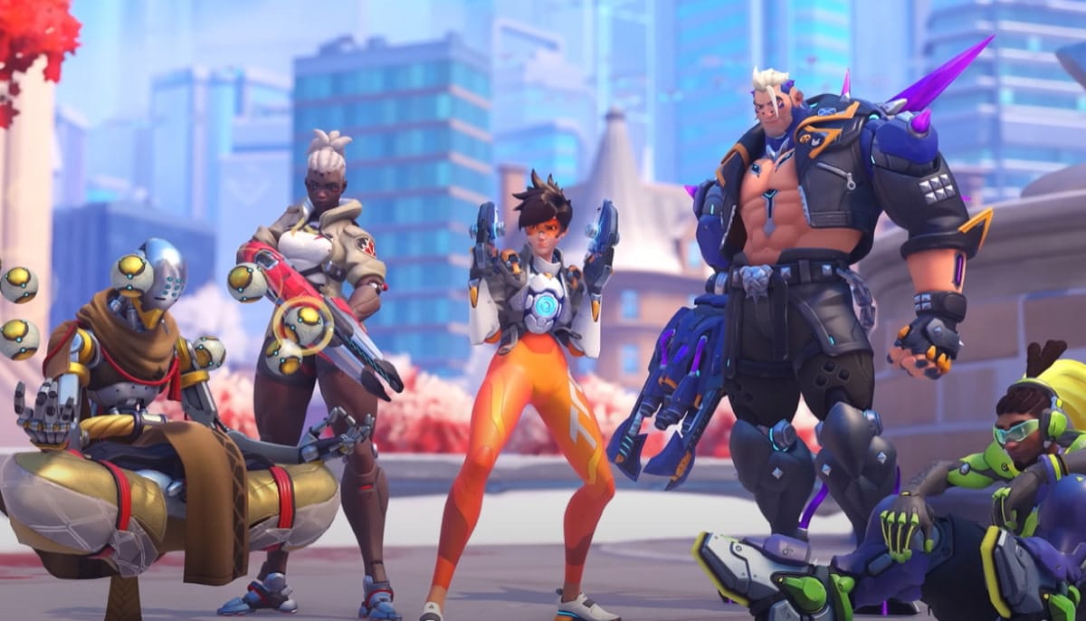 A group of five diverse characters from Overwatch 2 stand confidently in a futuristic cityscape. The scene conveys teamwork and readiness